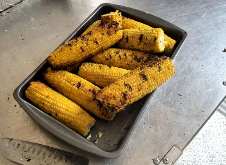 A tray of grilled corn on the cob, fresh off the grill